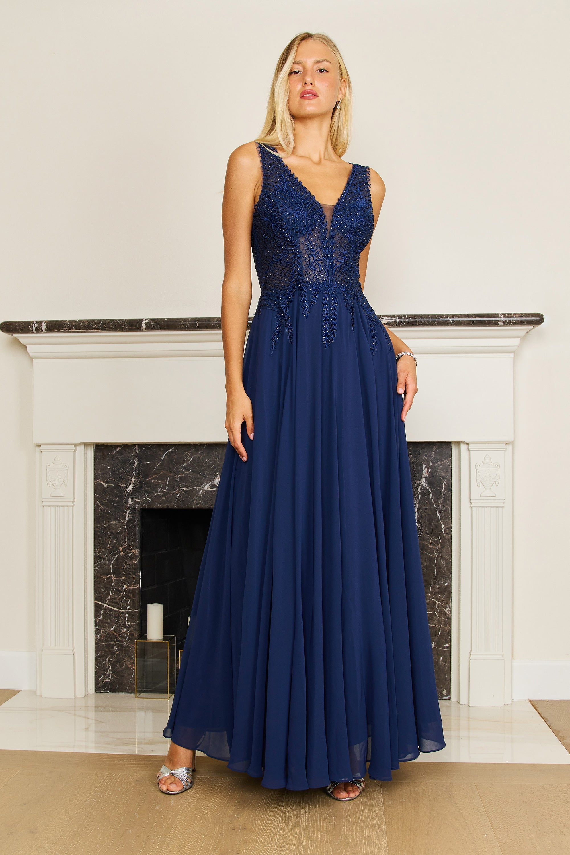 A plus-size woman elegantly wearing a long navy chiffon evening gown, showcasing a flowing silhouette and delicate details, perfect for formal occasions.