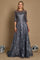 A long formal evening dress in charcoal gray, featuring intricate lace detailing and a flowing silhouette, elegantly draping to the floor.