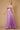 A stunning mauve prom dress featuring a long, sparkling cowl neckline and a fitted corset bodice, elegantly flowing into a full skirt that shimmers with every movement.